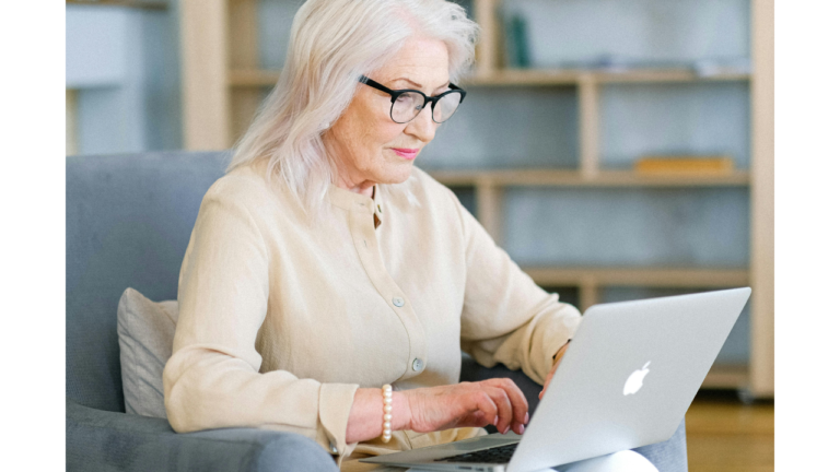 senior white woman typing on laptop freelancing in retirement